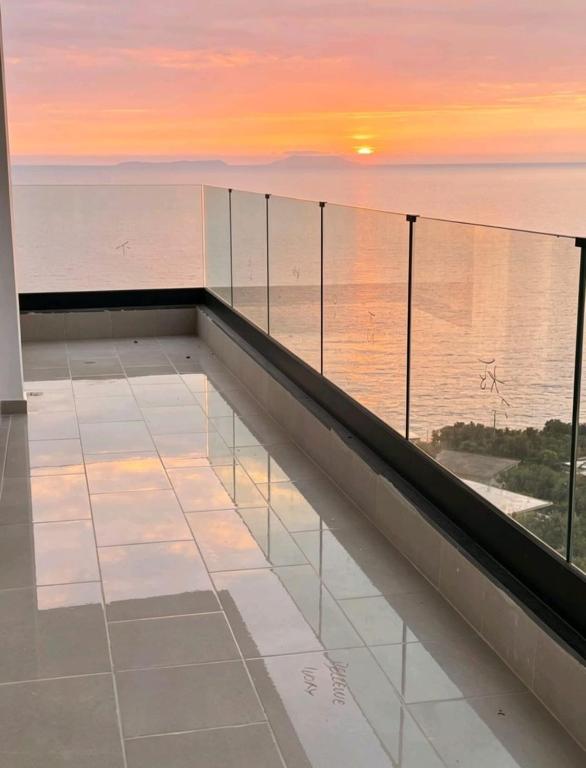 a balcony with a view of the ocean at sunset at Borsh sunset apartments in Borsh