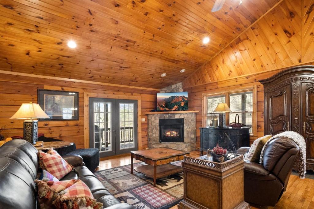 a living room with leather furniture and a fireplace at Eagles View in Boone