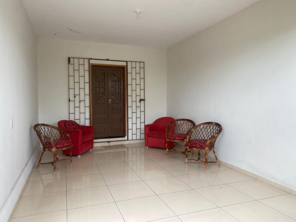 a waiting room with red chairs and a door at Casaavatar12 in Piranhas