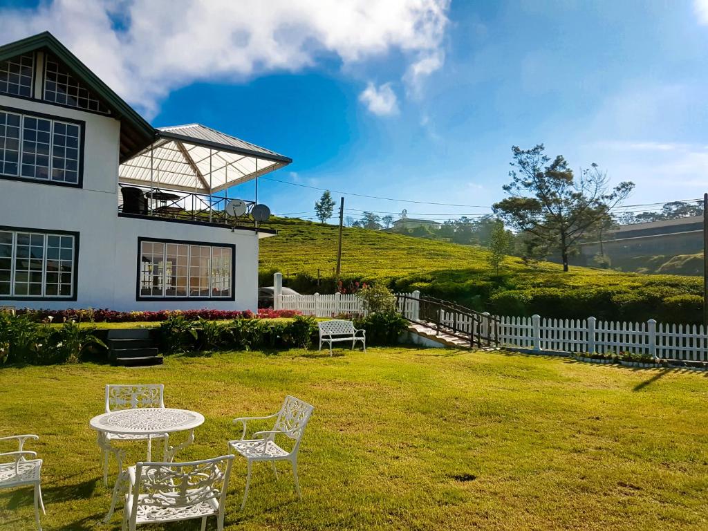 einen Tisch und Stühle im Hof eines Hauses in der Unterkunft The Tea Garden in Nuwara Eliya