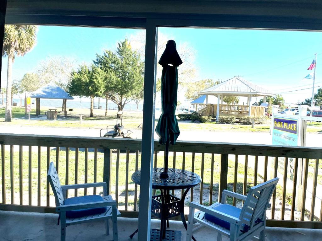 a patio with a table and two chairs and an umbrella at Cedar Key Florida Condo at Park Place in Cedar Key