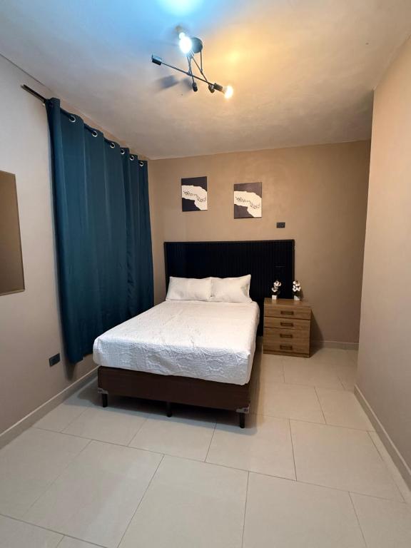 a bedroom with a bed and a blue curtain at Vista del Volcán in Santiago Atitlán