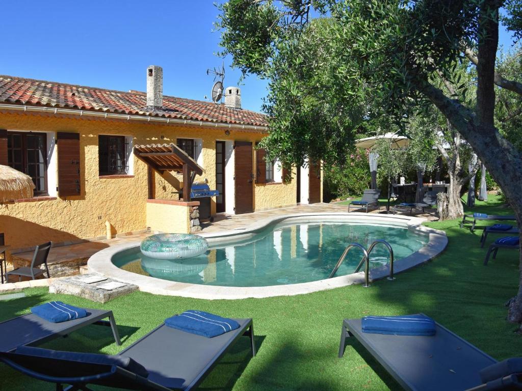 a backyard with a pool with chairs and a house at Le Rayol in Bagnols-en-Forêt