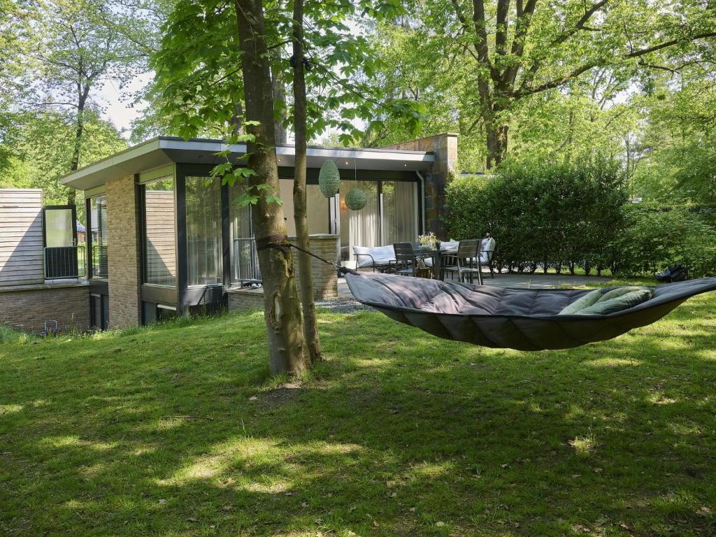 Eine Hängematte, die in einem Garten an einem Baum hängt in der Unterkunft De Douglas in Soesterberg