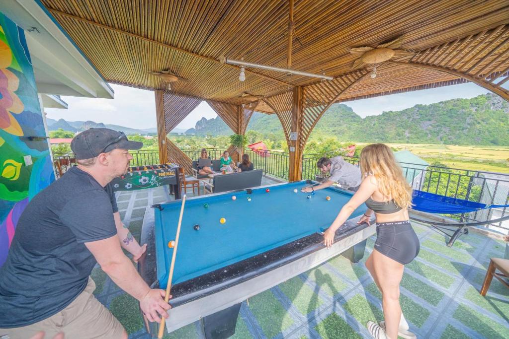 a man and a woman playing pool on a pool table at Green Riverside Cosy Home in Phong Nha