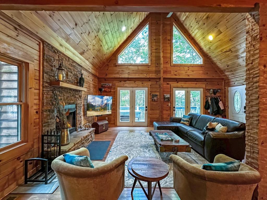a living room with a couch and a stone wall at A-Typical in Boone