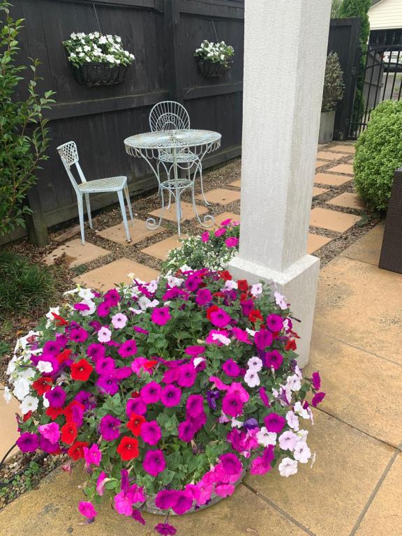 a table and a chair and flowers next to a pole at Private Retreat in Cambridge