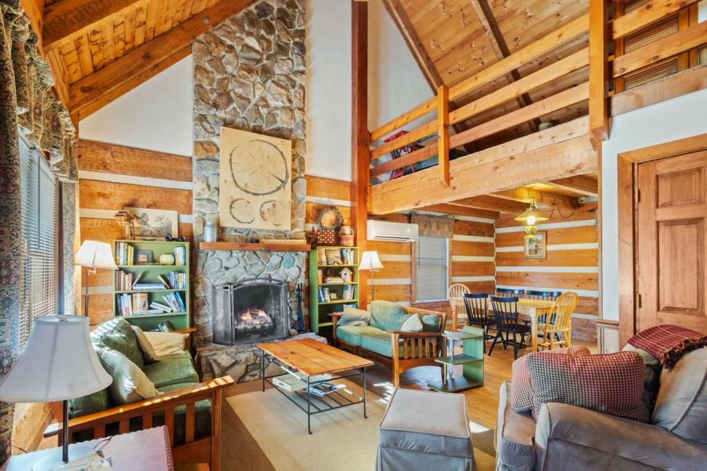 a living room with a fireplace and wooden ceilings at Trailhead Cabin in Boone