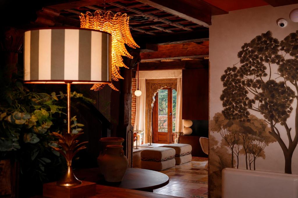 a living room with a chandelier and a table at Posada San Miguel Arcángel Experience in Arévalo