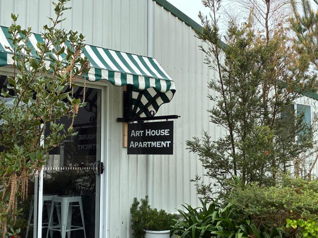 an art house apartment sign on the side of a building at MOWA Art House Apartment in Huonville