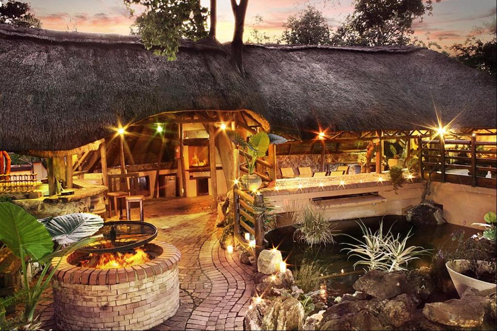 a restaurant with a fire pit and a building at Centurion Guest House and Lodge in Centurion