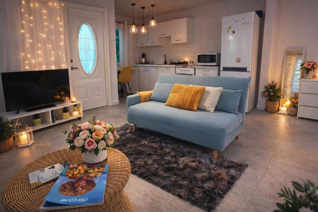 a living room with a blue couch and a table at Tree House in Saint Martin