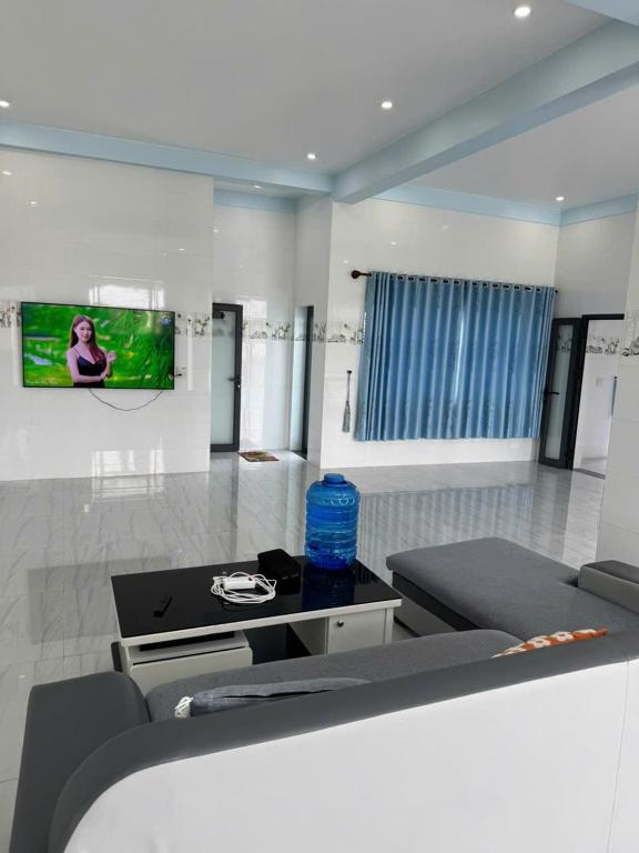 a living room with a couch and a tv on the wall at KEN Homestay in Cu Lao Thu