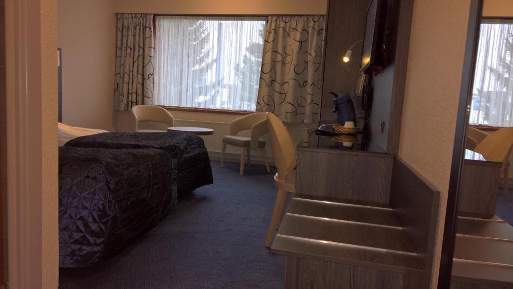 a hotel room with a bed and a stair case at Hotel Falster in Nykøbing Falster
