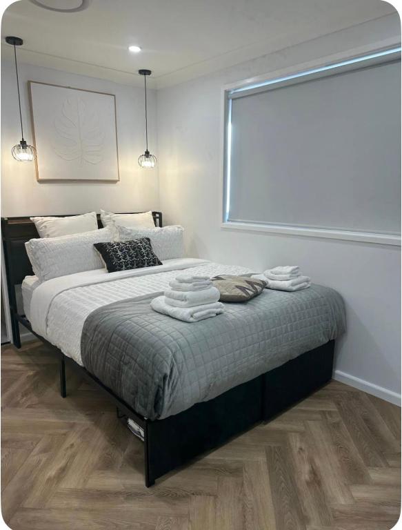 a bedroom with a large bed with towels on it at Resort-style living -pool in Bass Hill