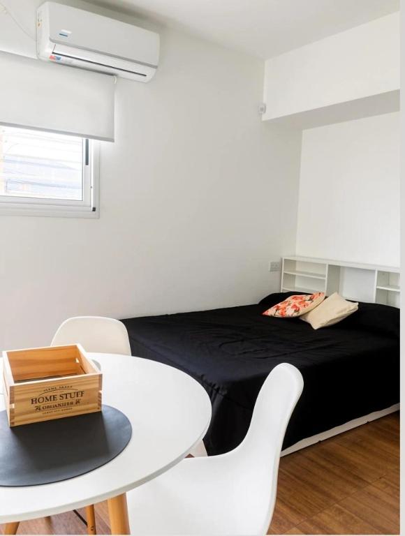 a room with a bed and a table and chairs at Apart Casa de Piedra in San Luis