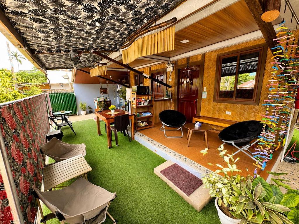 a living room with green carpet and a room with chairs at Nay Carmen Pension House Port Barton in Itaytay