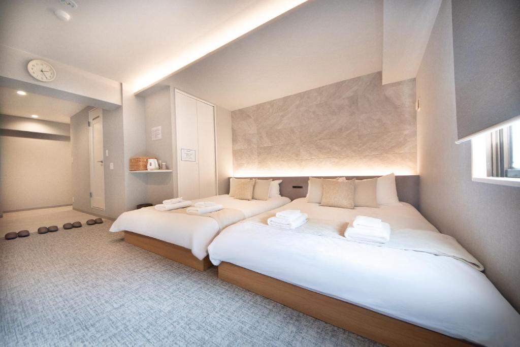 two twin beds in a room with at Hotel Neiraku in Nara