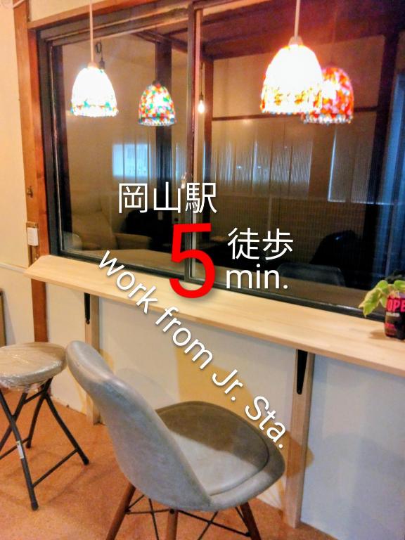 a room with a counter with a table and two chairs at OKAYAMA Backpackers in Okayama
