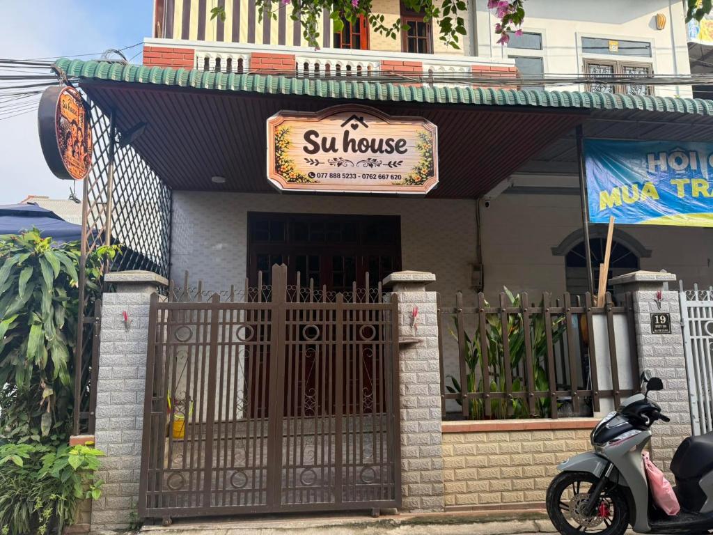 a scooter parked in front of a house with a gate at SU HOUSE Huế in Hương Trà