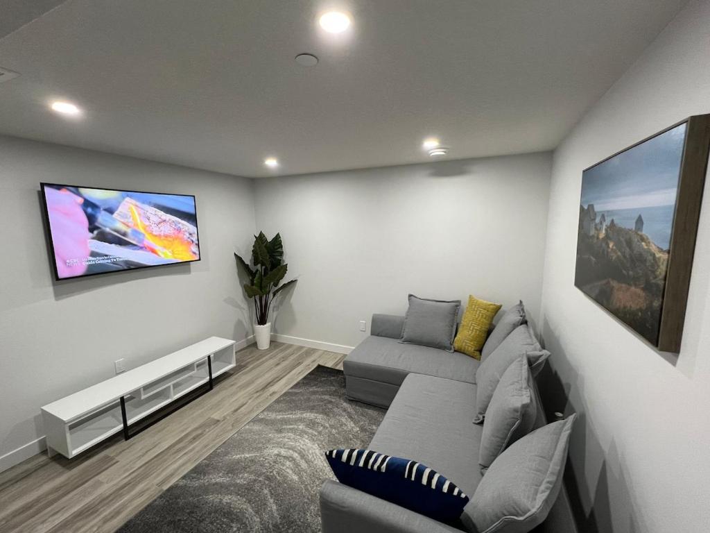 a living room with a couch and a flat screen tv at Charming 1Bd Basement Suite with Private Entrance in Calgary