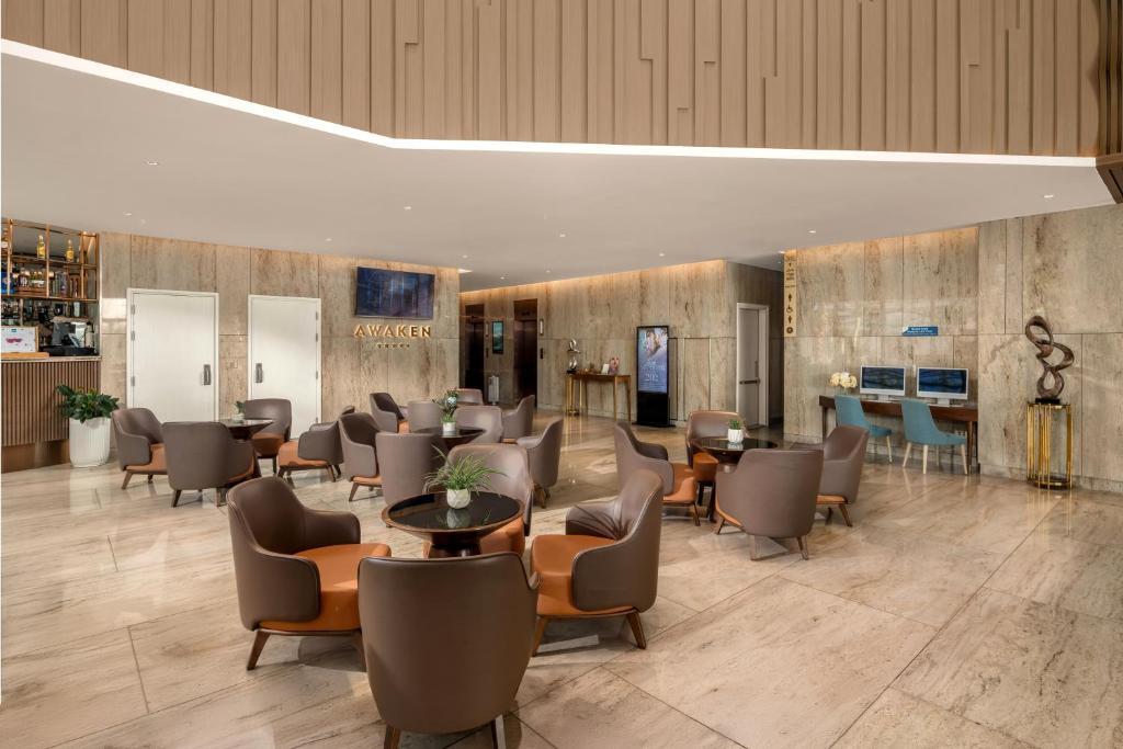 A spacious marble lobby lounge with armchairs, small tables and a reception area.
