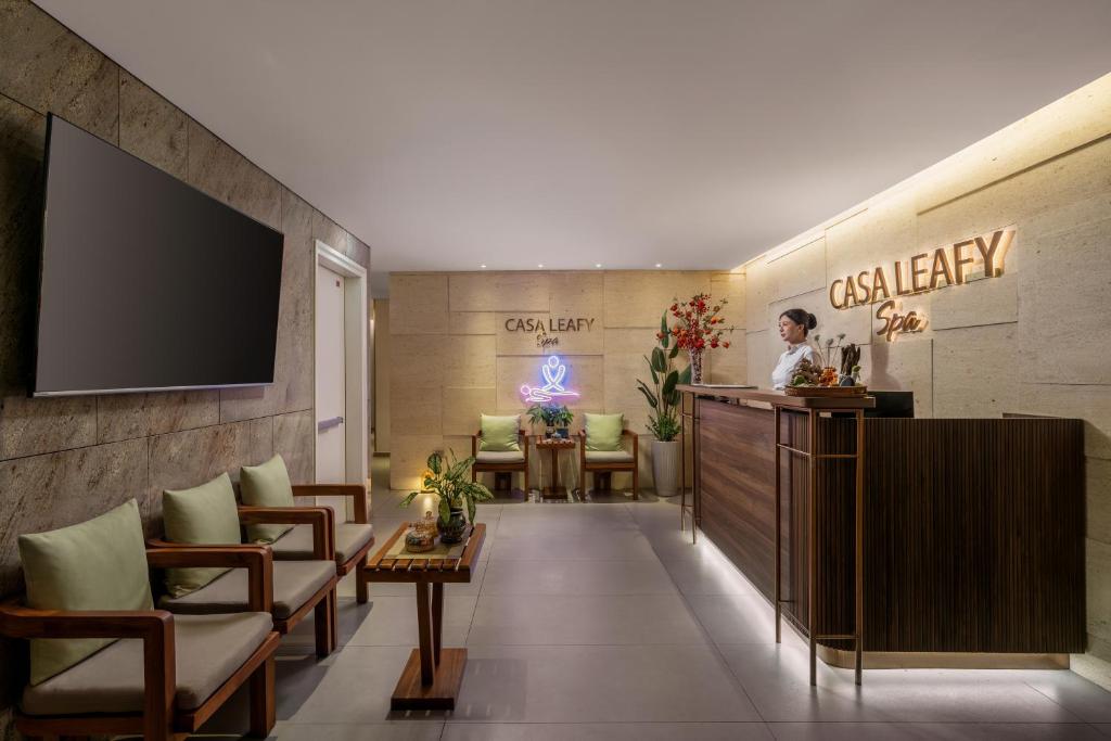 A compact lounge and spa reception area with a wall-mounted television.