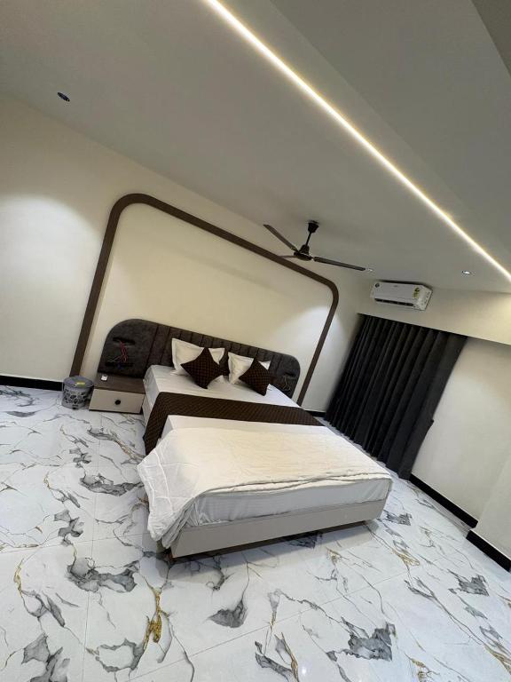 a bedroom with a bed with a marble floor at Hotel D Lite Inn in Junagadh