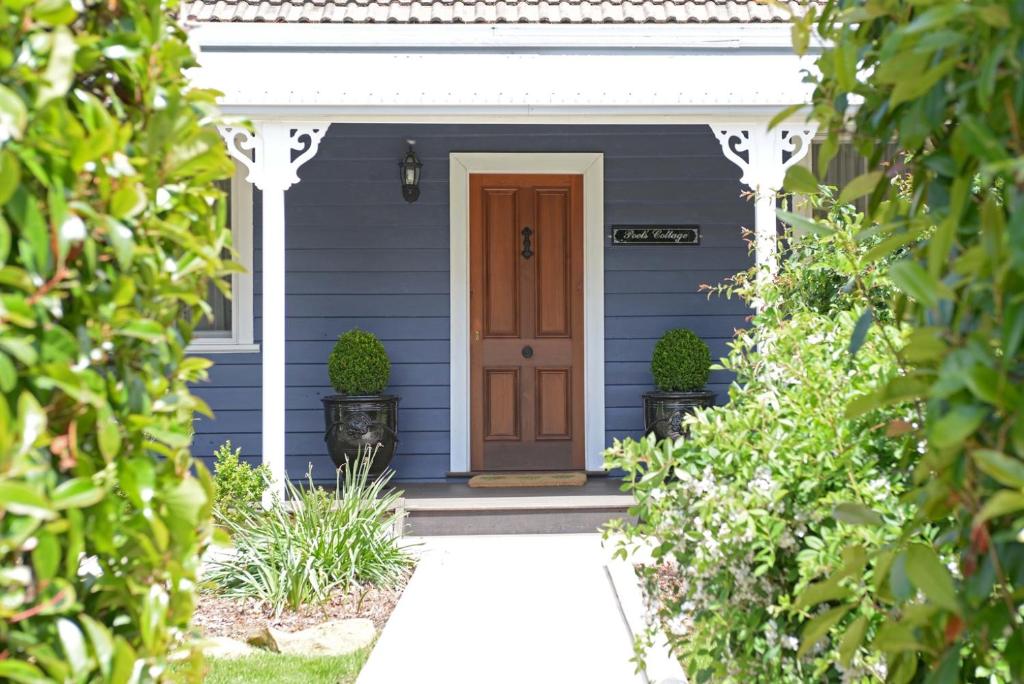 a blue house with a brown door and plants at Poets Cottage c1912 Scenic Hikes, Fire, Spa Bath in Wentworth Falls