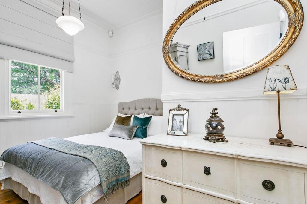 a bedroom with a bed and a mirror at Gowan Brae Cottage - NEW! in Katoomba