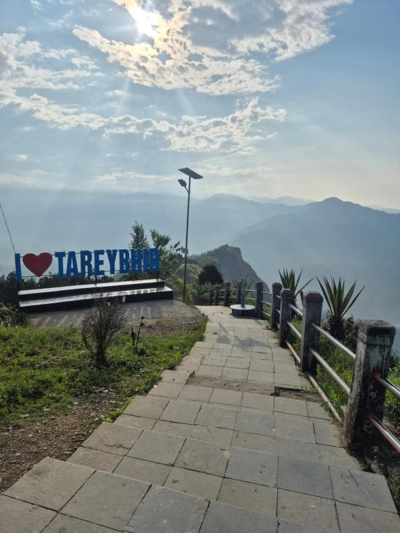 a walkway with a sign on the side of a mountain at Aadharjun Homestay in Chidām