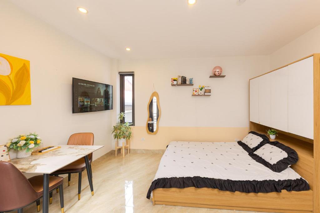 a bedroom with a bed and a dining room at Gấu Studio Ngoại Giao Đoàn in Hanoi
