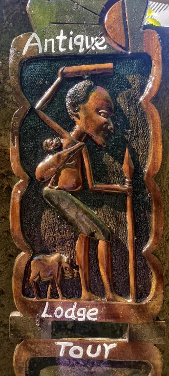 a sign with a picture of a man playing baseball at Antique Lodge in Arusha