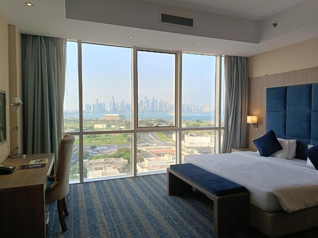 a hotel room with a bed and a large window at The CASTLE PREMIUM HOTEL in Doha