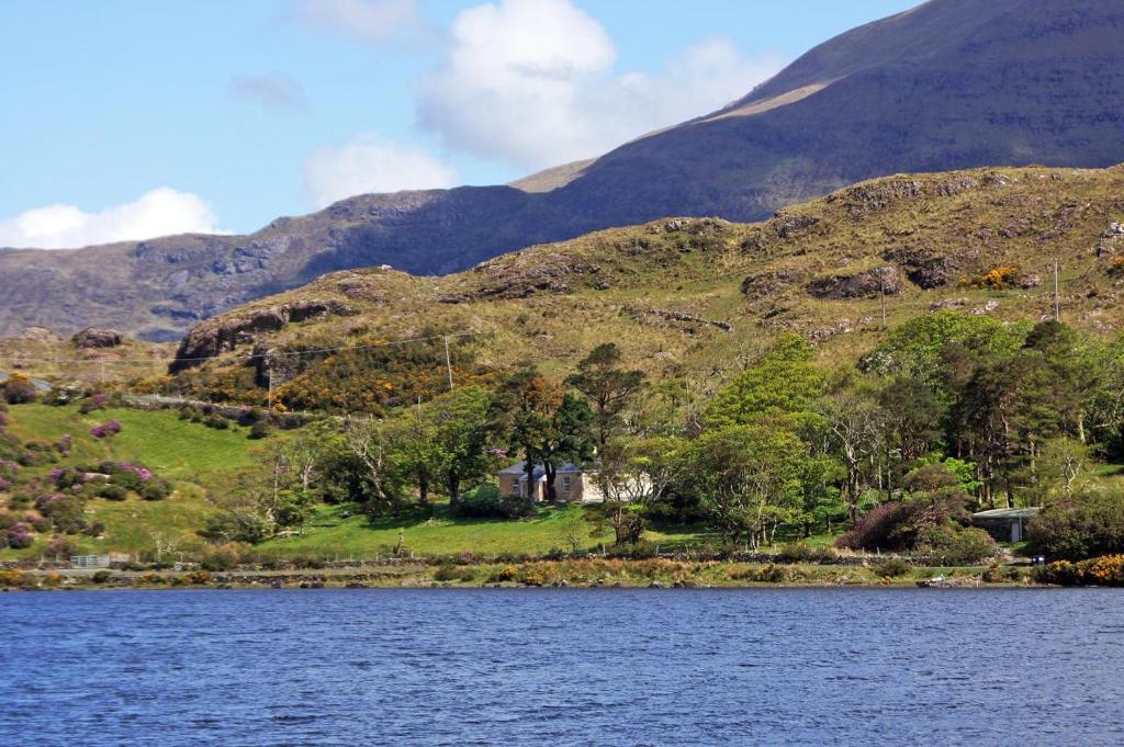 a house on the shore of a lake with mountains in the background at 4 Bed in Renvyle oc-i258 in Salrock