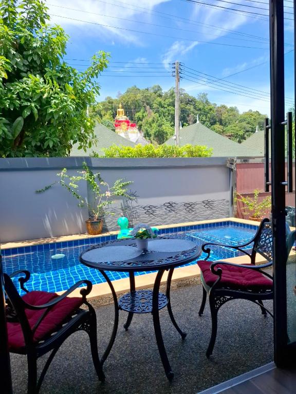 a patio with a table and two chairs and a pool at Peaceful Pool Villa 1 in Ao Nang Beach
