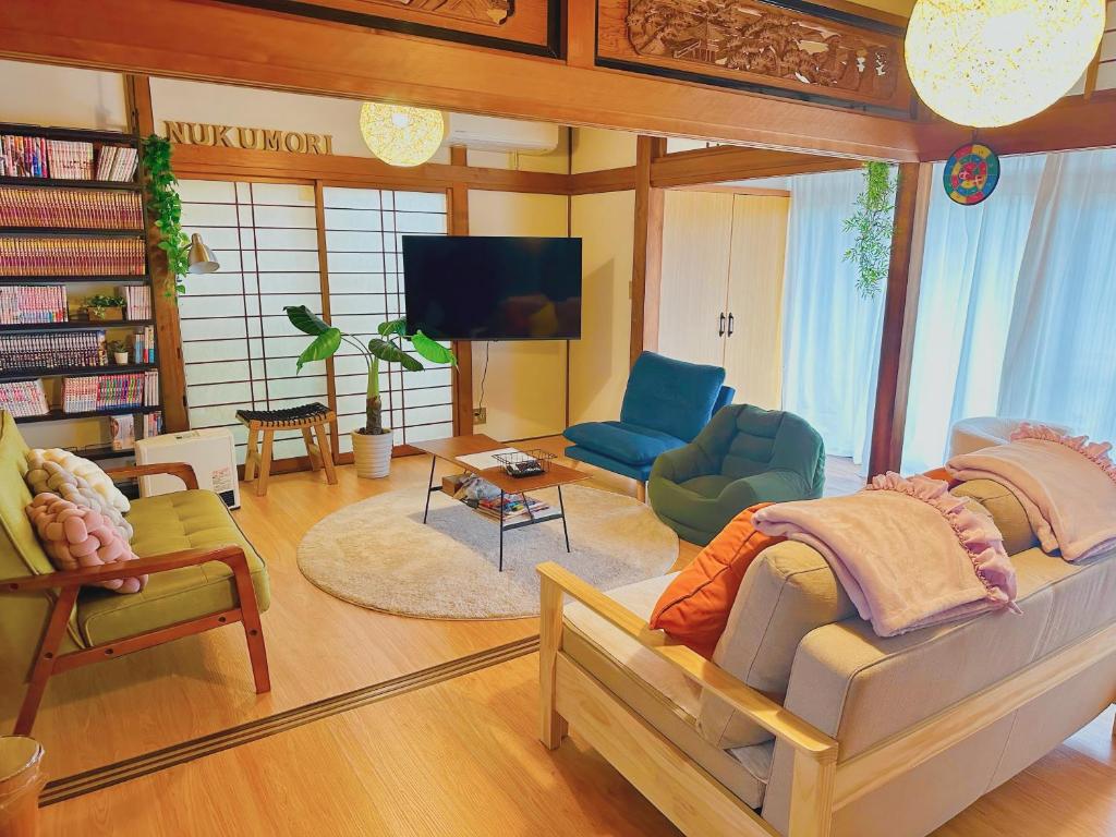 a living room filled with furniture and a flat screen tv at Nagoya kiyosu温もりの宿貸切一軒家駅近3分 in Nishi-biwajima