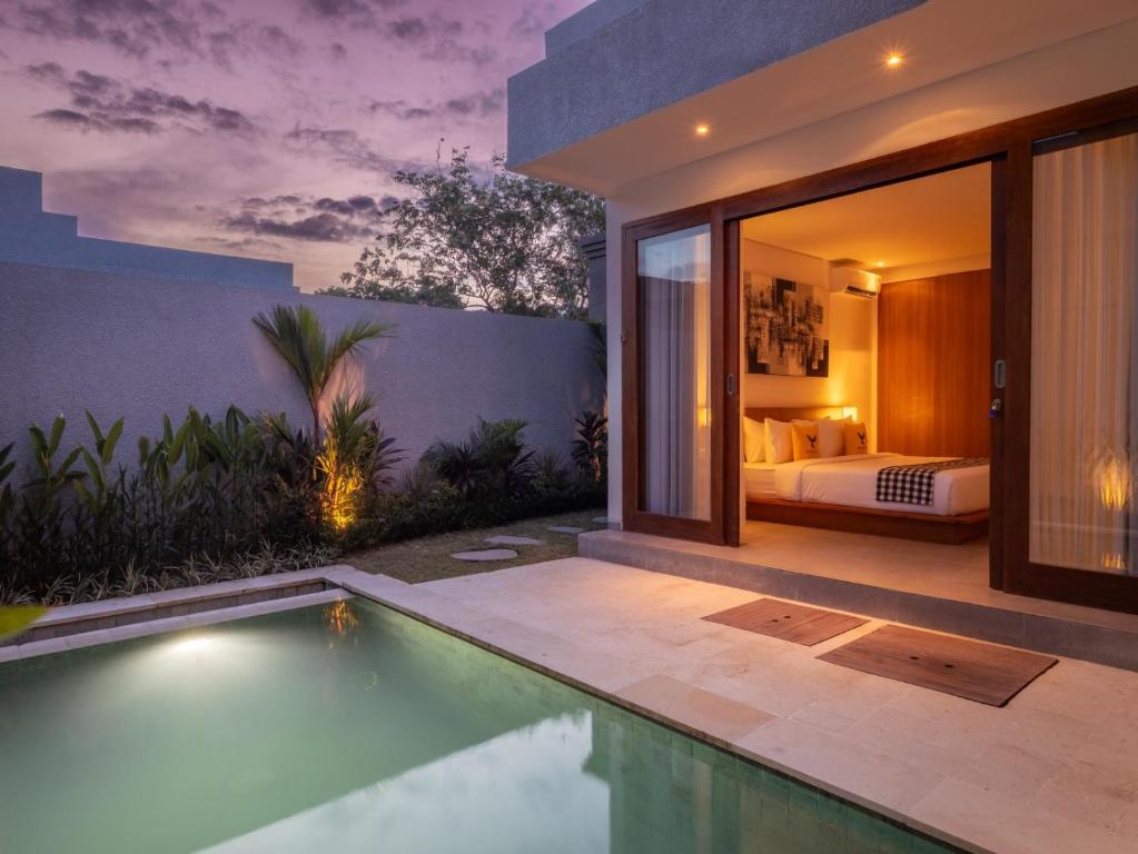 a bedroom in a villa with a swimming pool at Prawara Uluwatu in Uluwatu