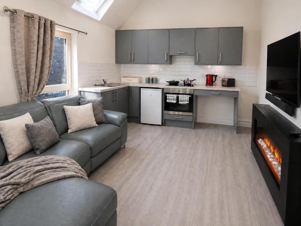 a living room with a couch and a kitchen at Unit 3 Modern Self Contained Apartment in Cobh