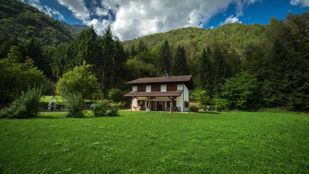 a house in the middle of a green field at Casa al Portico in Ledro