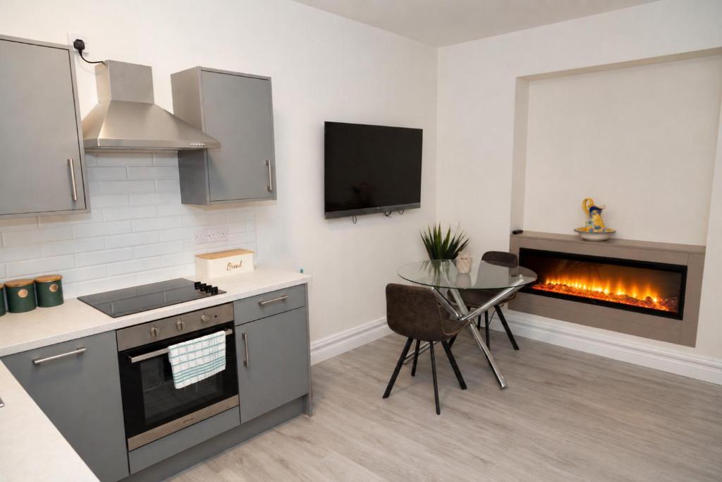 a kitchen with a stove and a table and a fireplace at Unit 1 Island View Apartments - Town Centre Walk To Everything in Cobh