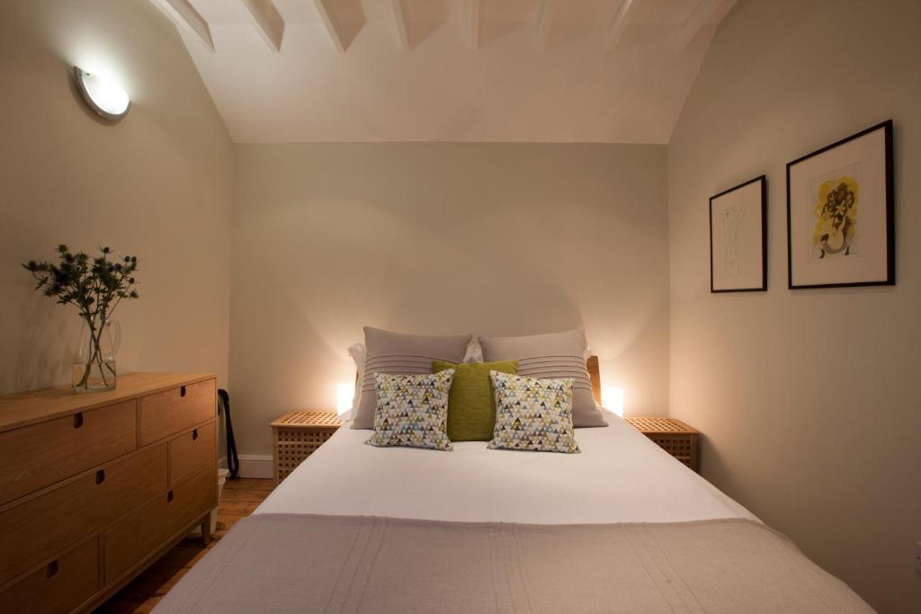 a bedroom with a white bed with two pillows at The Byre - 2 bedroom cottage in Pewsey