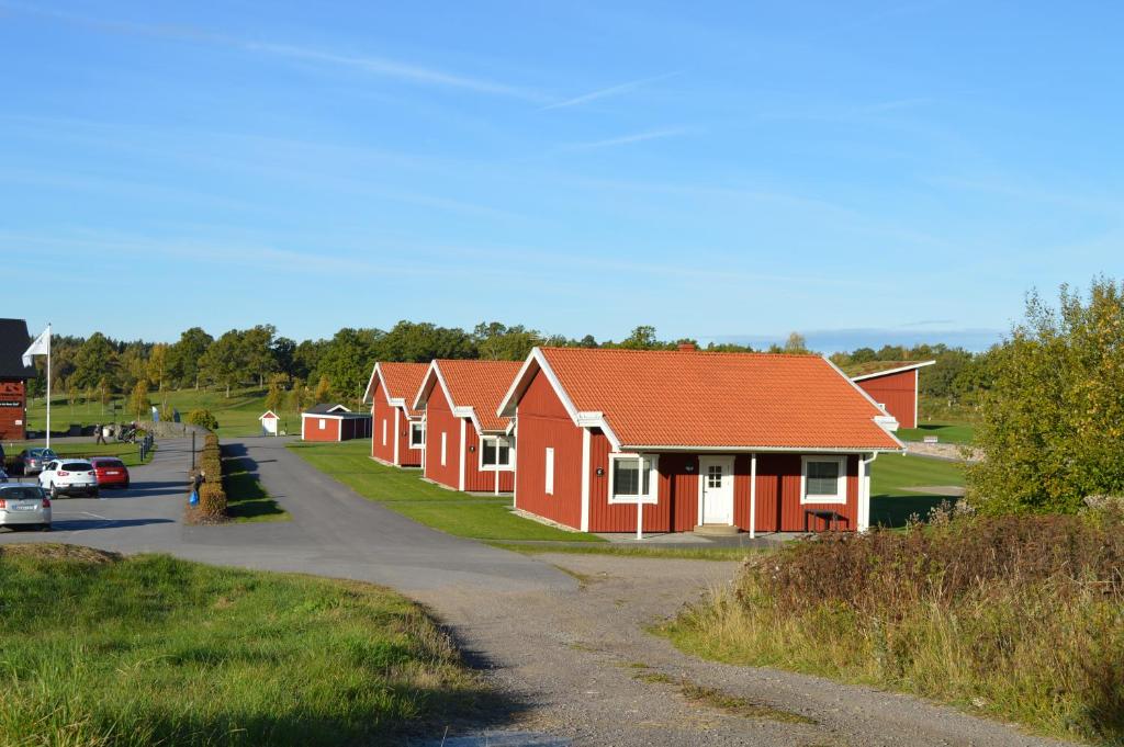 una fila de casas rojas en una carretera en Vreta Kloster Golfklubb, en Ljungsbro