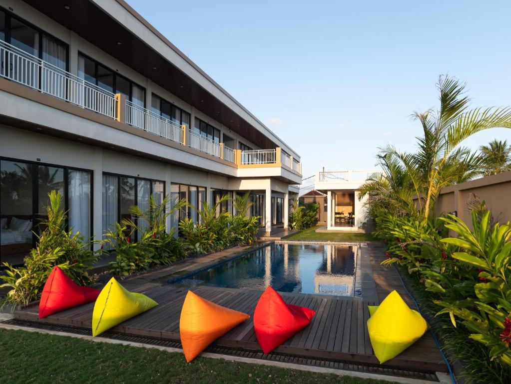 a hotel with colorful pillows in front of a swimming pool at Pondok Uma Jero in Tanah Lot