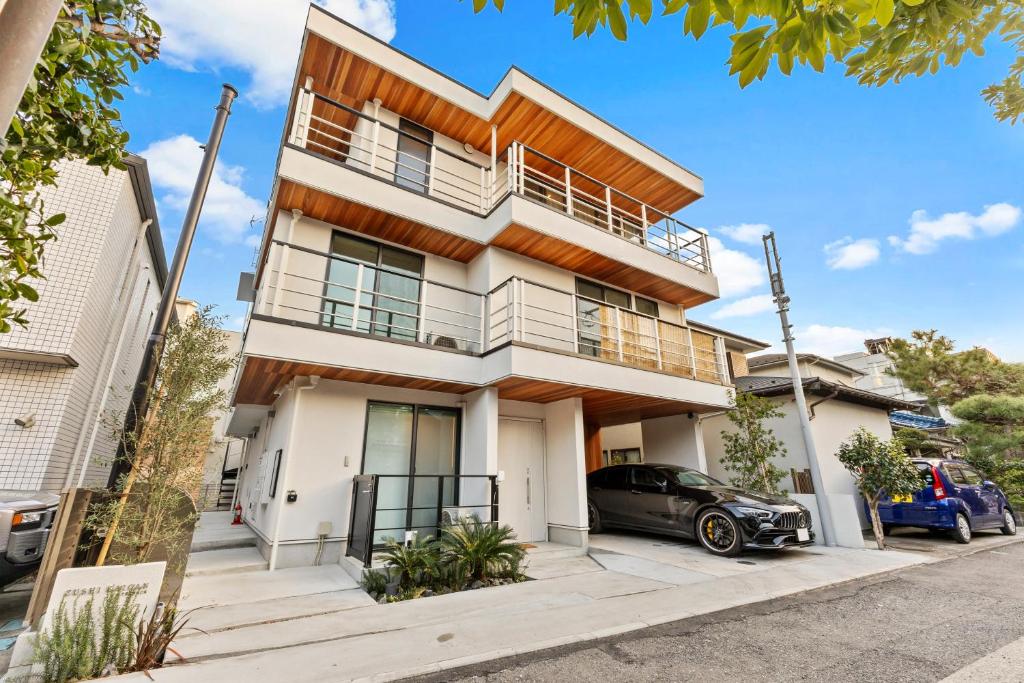 a house with a car parked in front of it at 逗子海岸テラス 2階 in Zushi