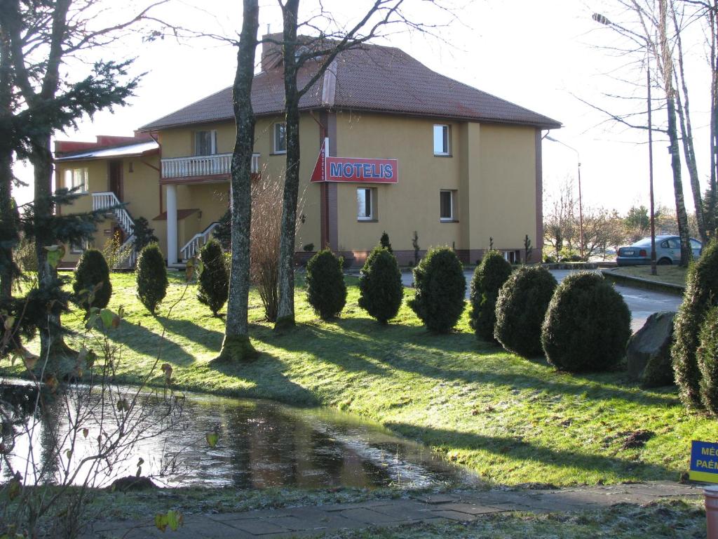 a hotel with a motel sign in front of a building at Piligrimo Užeiga in Kadarės