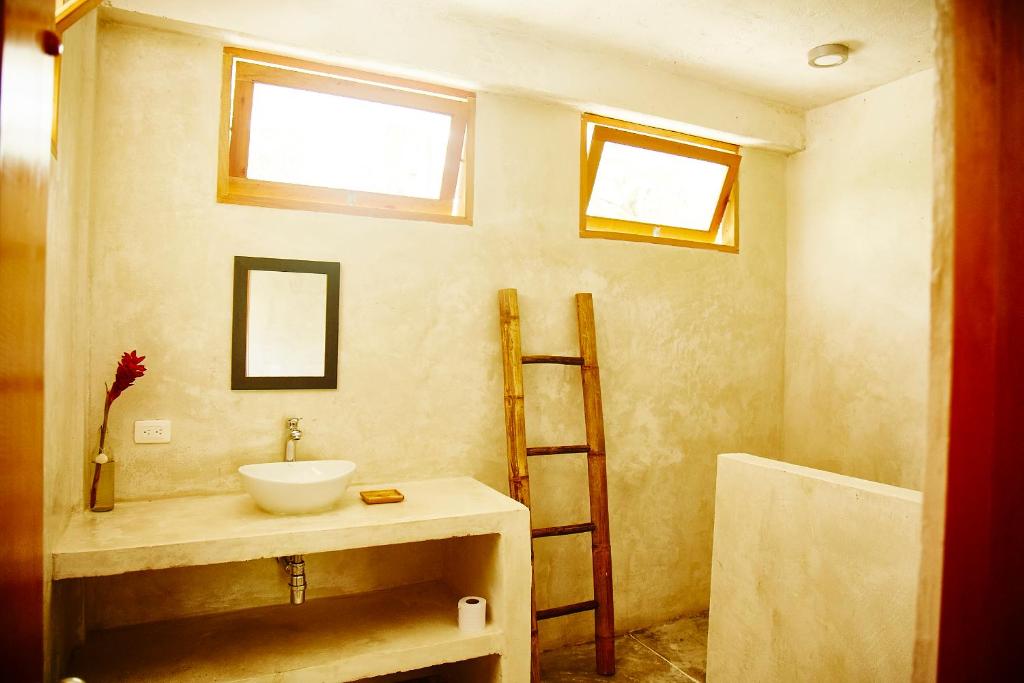 a bathroom with a sink and a ladder and windows at Casa Chapolin Boutique Guesthouse in Palomino