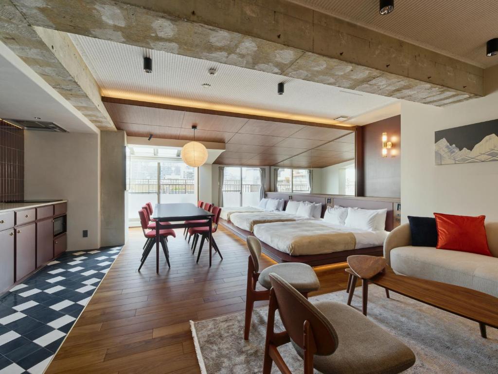 a room with four beds and a table and chairs at illi Tex Aoyama in Tokyo