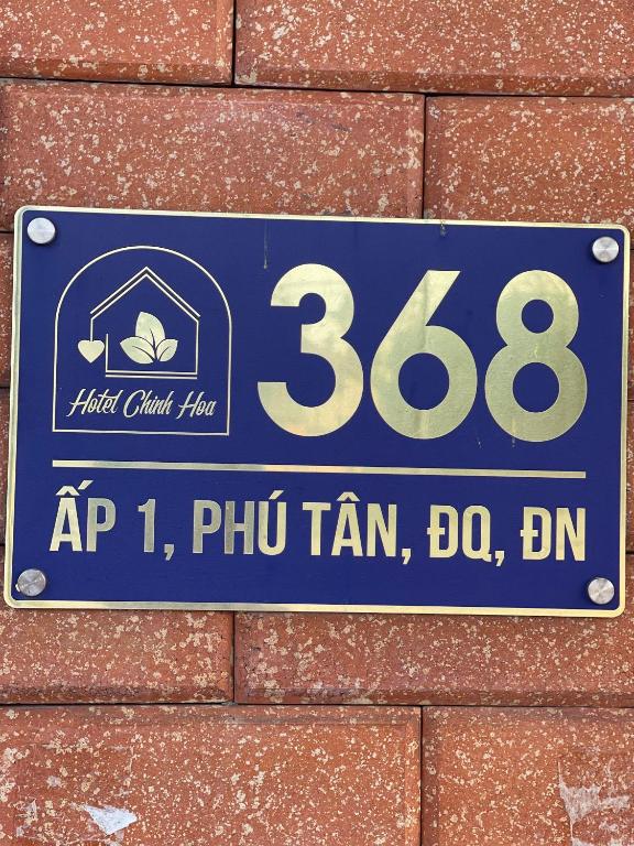 a sign on the side of a brick wall at Hotels Motel Nhà nghỉ CHINH HOA PLASS in Ấp Ray
