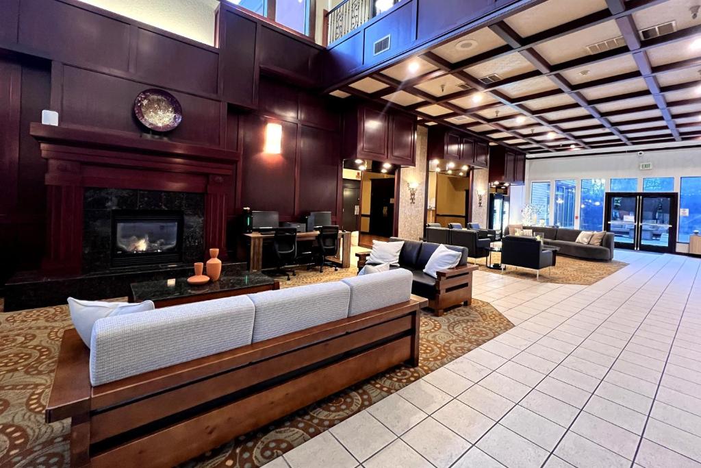 a living room with a couch and a fireplace at Ramada by Wyndham Tukwila Southcenter in Tukwila